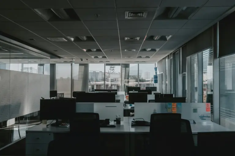 bureau moderne vide avec postes de travail, baies vitrées et vue urbaine