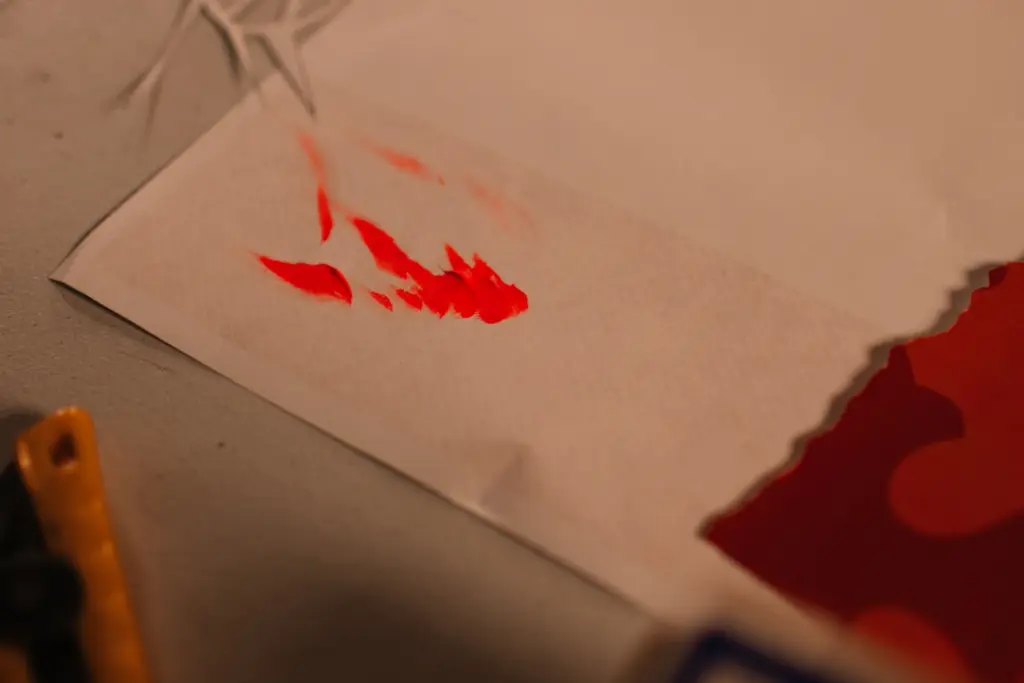 Red paint splatters on white paper