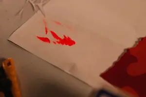 Red paint splatters on white paper