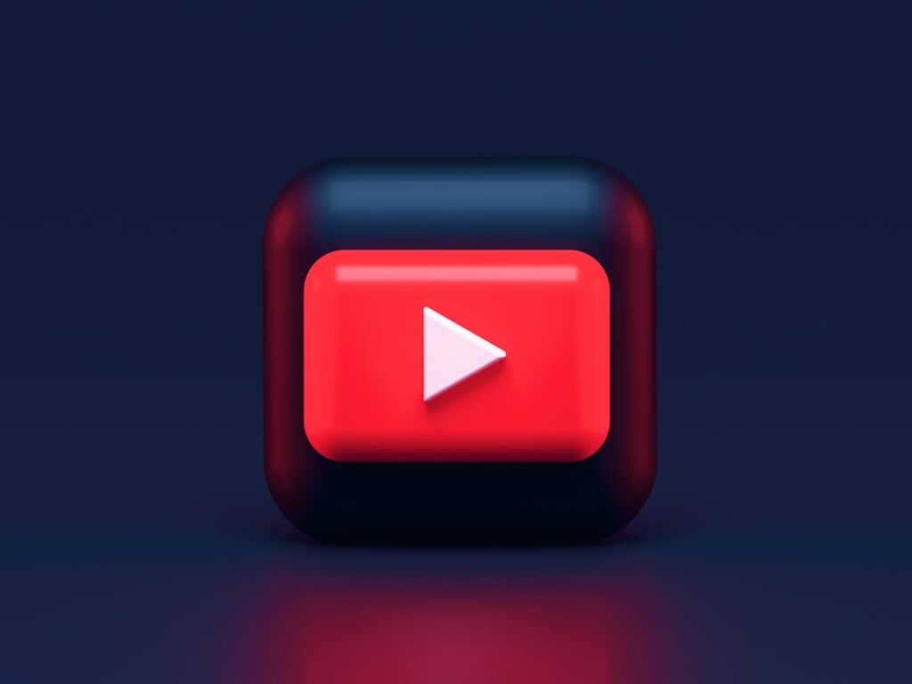 A 3D red play button icon on a dark blue background